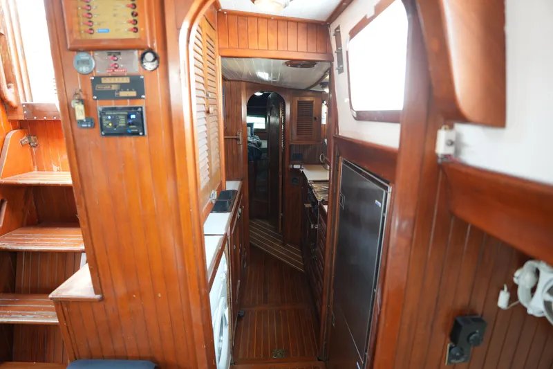 Slide: The Image of Interior of 1982 Vagabond 47 sailboat with wooden paneling and compact galley. - 29