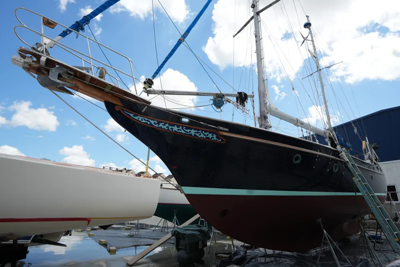 Slide: The Image of Sailboat Vagabond 47, 1982 model, docked for maintenance under a bright blue sky. - 3