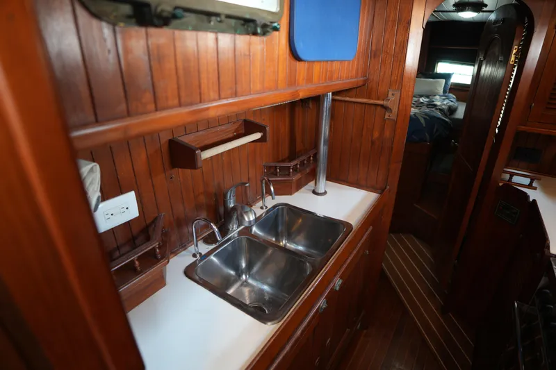 Slide: The Image of Wood-paneled kitchen area in 1982 Vagabond 47 sailboat with stainless steel sink. - 31
