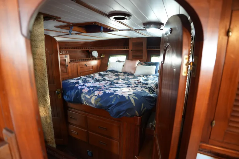 Slide: The Image of Cozy wooden cabin interior of 1982 Vagabond 47 sailboat with floral bedding. - 33