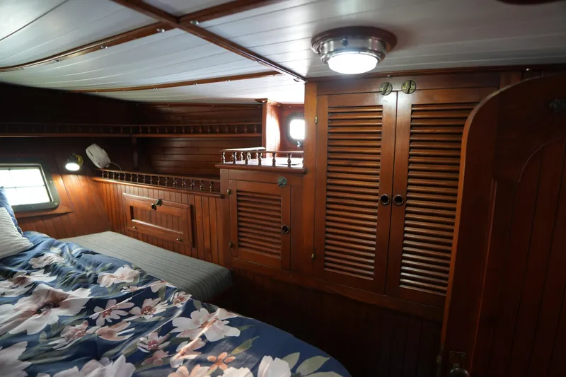 Slide: The Image of Cozy wooden cabin interior of 1982 Vagabond 47 sailboat with floral bedding. - 34