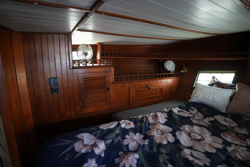 Slide: The Image of Cozy wooden cabin interior of 1982 Vagabond 47 sailboat with floral bedding. - 35