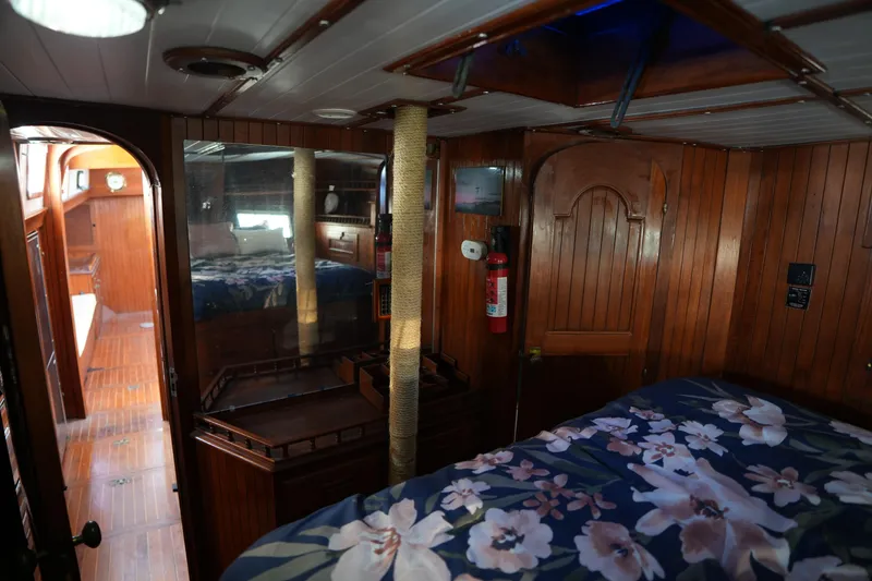 Slide: The Image of Interior of 1982 Vagabond 47 sailboat with wood paneling and floral bedding. - 36