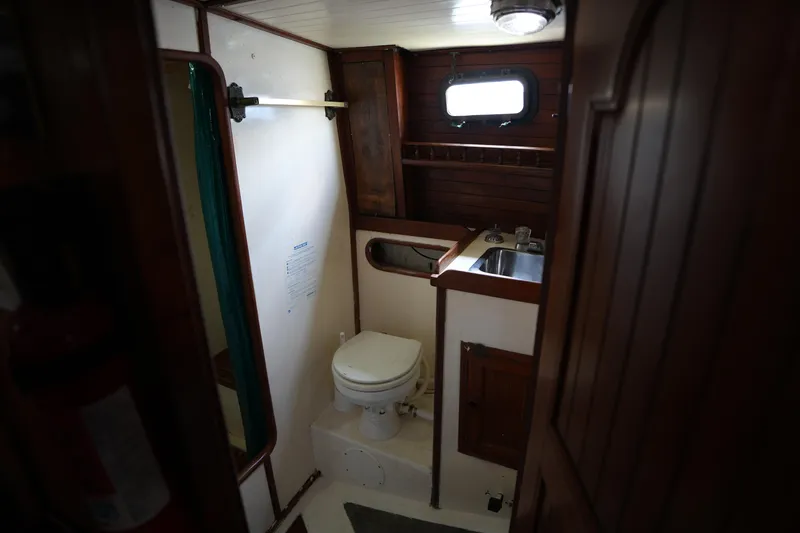 Slide: The Image of Interior of 1982 Vagabond 47 sailboat bathroom with wooden cabinetry and compact design. - 37