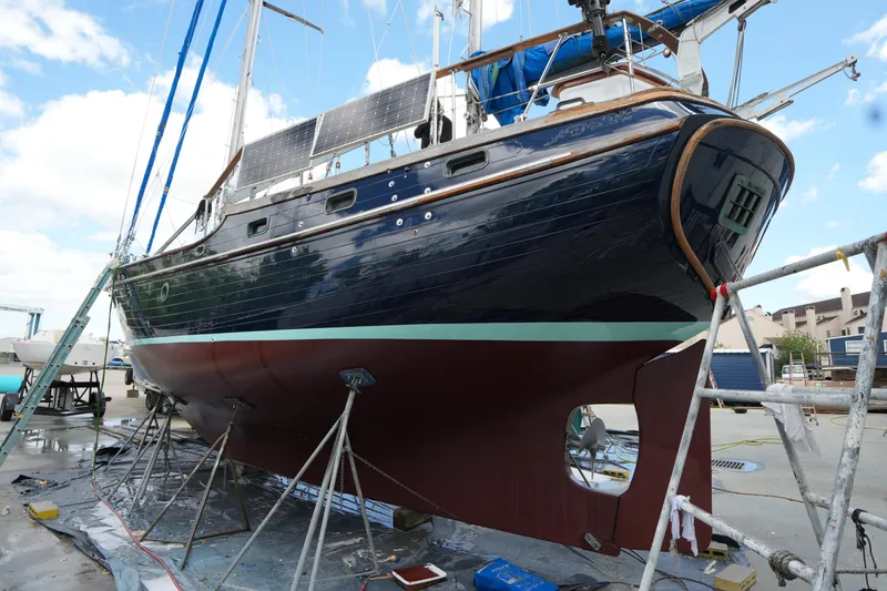 Slide: The Image of 1982 Vagabond 47 sailboat on dry dock, undergoing maintenance with solar panels visible. - 4