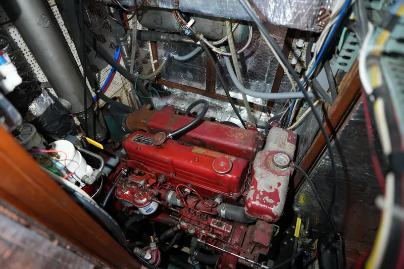 Slide: The Image of Engine compartment of a 1982 Vagabond 47 sailboat, featuring a red engine. - 40