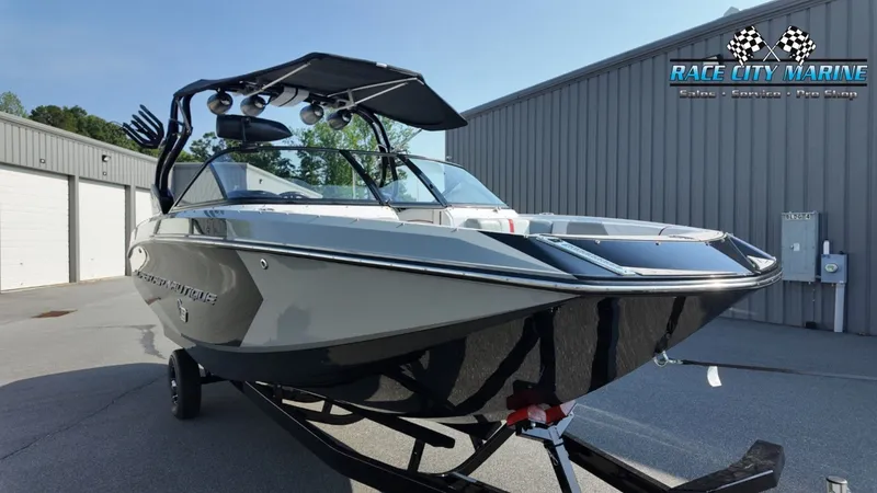 Slide: The Image of A 2013 Nautique G23 boat on a trailer in front of a gray building. - 5