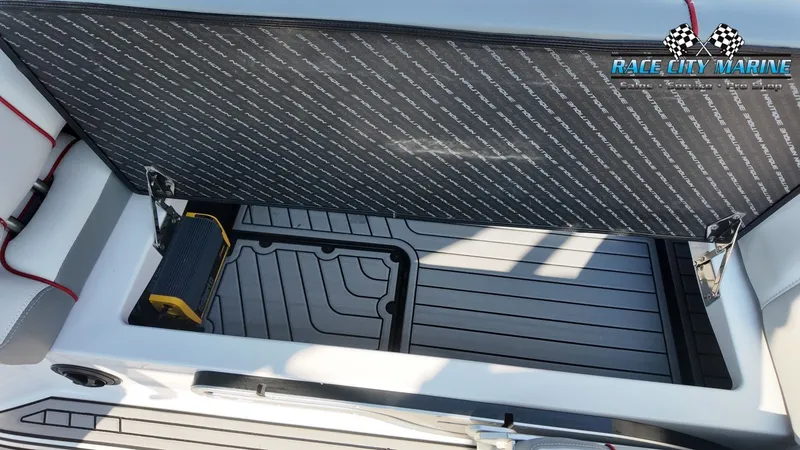 Slide: The Image of An open storage compartment on a 2013 Nautique G23 boat with gray flooring. - 45