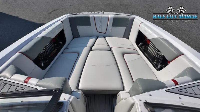 Slide: The Image of The image shows the bow area of a 2013 Nautique G23 boat with gray and white upholstery. - 20