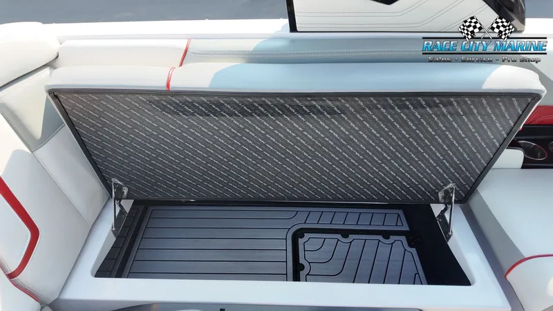 Slide: The Image of An open storage compartment on a 2013 Nautique G23 boat, featuring a cushioned lid. - 46