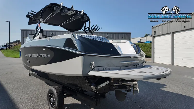 Slide: The Image of A 2013 Nautique G23 boat on a trailer in front of a building. - 7