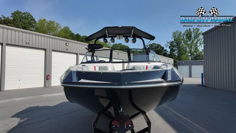 Slide: The Image of A black 2013 Nautique G23 boat on a trailer in front of garages. - 3