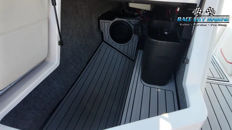 Slide: The Image of Interior of a 2013 Nautique G23 with gray carpeting and a speaker. - 38