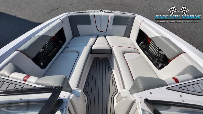Slide: The Image of Interior view of a 2013 Nautique G23 with gray and white seating, red accents, and cup holders. - 48