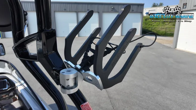 Slide: The Image of A wakeboard rack on a Nautique G23 boat, in front of a building with garage doors. - 33