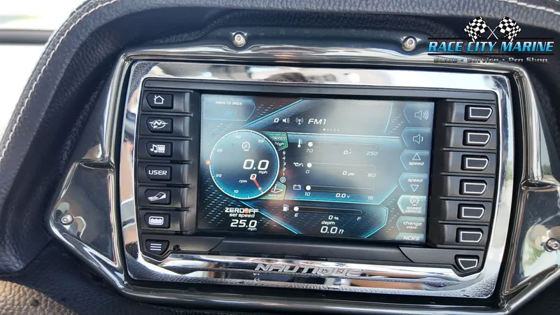 Slide: The Image of The image shows a modern control display of a 2013 Nautique G23 boat. - 40