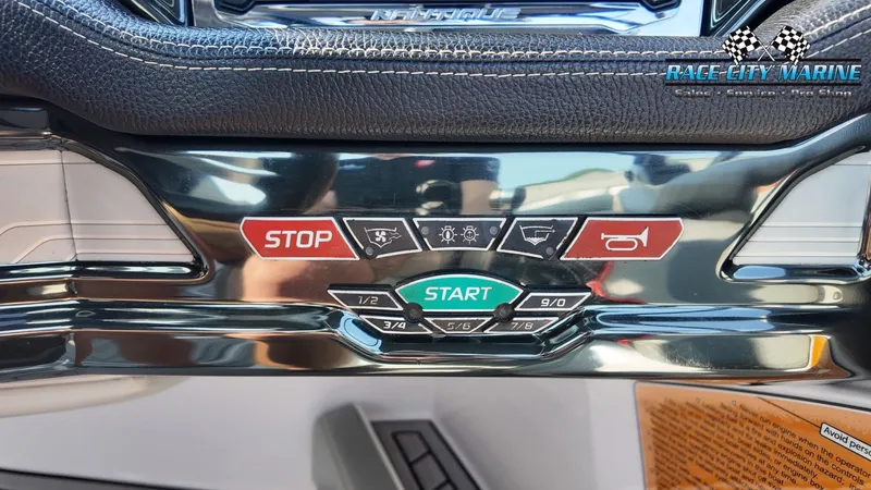 Slide: The Image of Close-up of a 2013 Nautique G23 control panel with start and stop buttons. - 34