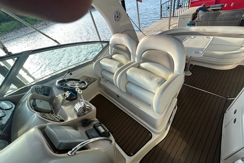 Slide: The Image of 2003 Sea Ray 340 Sundancer cockpit with dual seats and steering wheel, overlooking water. - 11