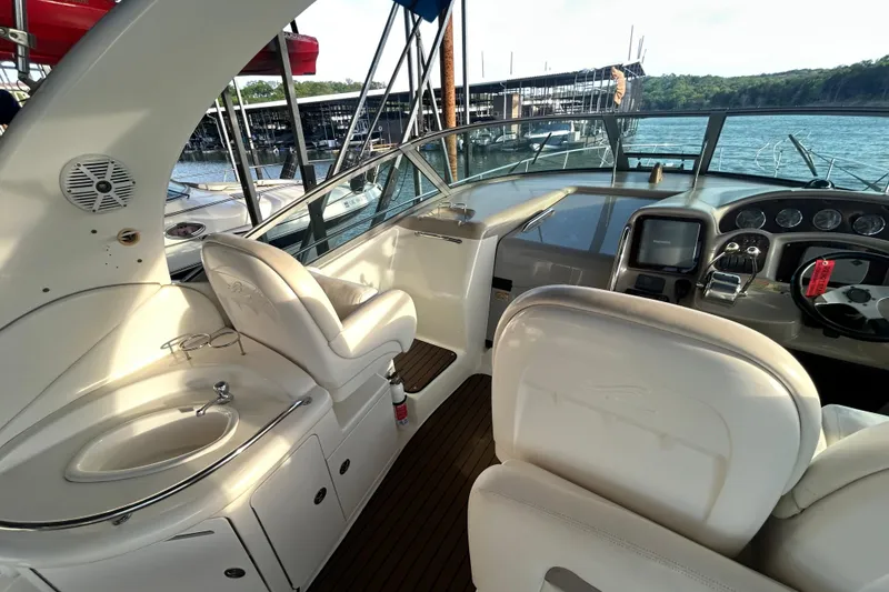 Slide: The Image of 2003 Sea Ray 340 Sundancer cockpit with helm, seating, and marina view. - 13