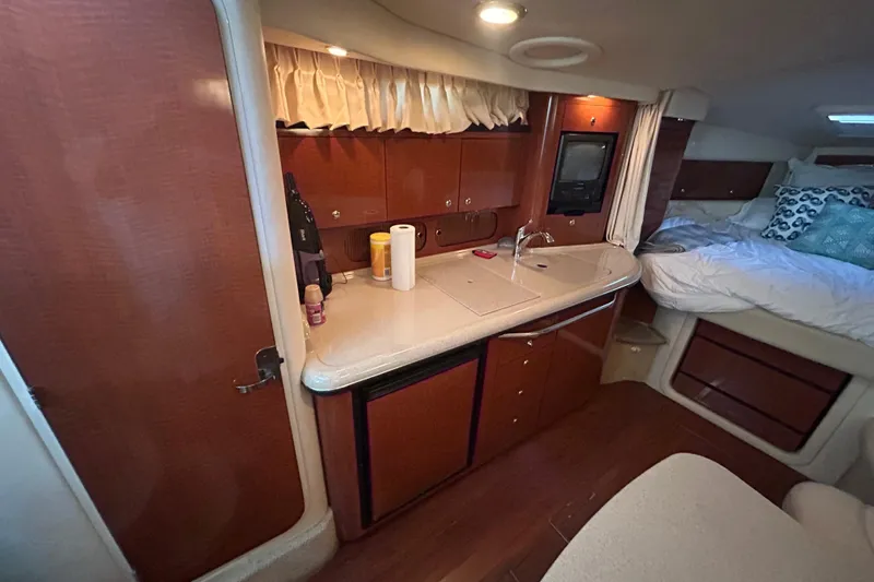 Slide: The Image of Interior of 2003 Sea Ray 340 Sundancer yacht with kitchenette and cozy sleeping area. - 18