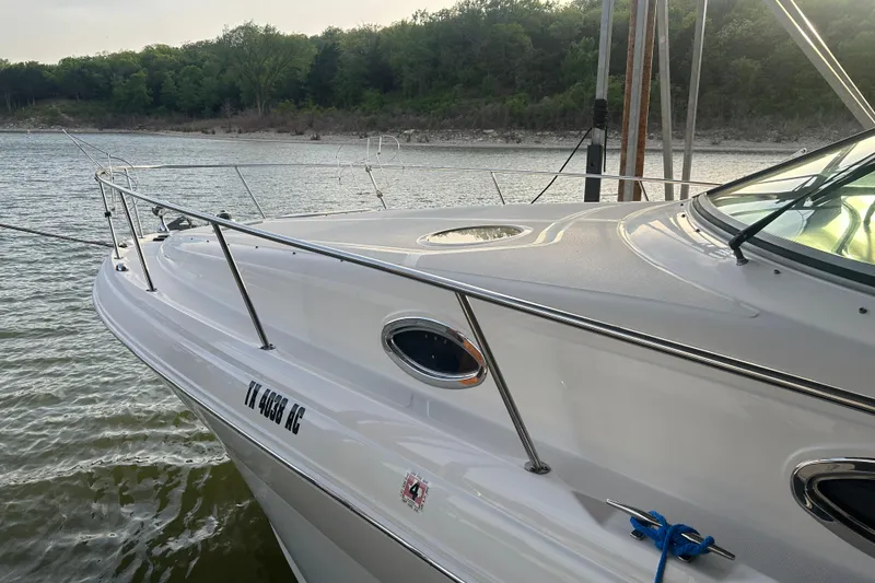 Slide: The Image of 2003 Sea Ray 340 Sundancer yacht docked on calm water with lush green shoreline. - 3
