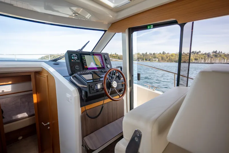 Slide: The Image of Interior helm of 2024 Greenline 39 yacht with modern navigation equipment and scenic water view. - 17