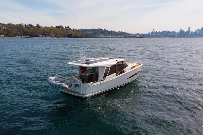 Slide: The Image of 2024 Greenline 39 yacht cruising on open water with city skyline in background. - 4