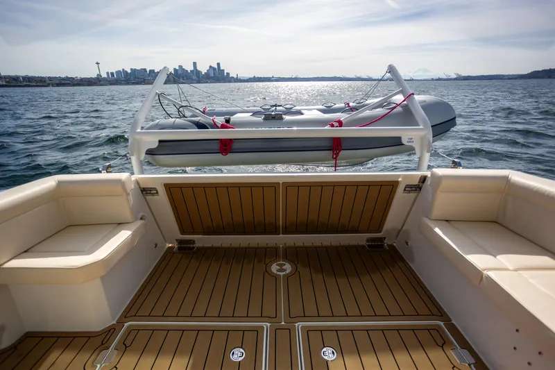 Slide: The Image of 2024 Greenline 39 yacht deck with city skyline and inflatable boat in background. - 6