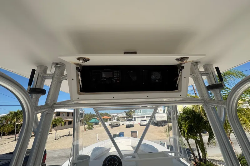 Slide: The Image of 2006 Regulator 24 Classic boat console with electronics, viewed from below, in a sunny setting. - 14