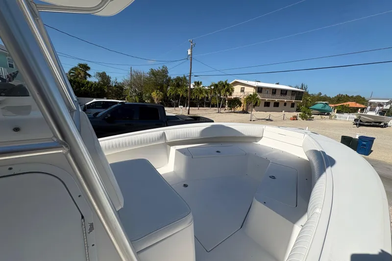 Slide: The Image of 2006 Regulator 24 Classic boat with spacious seating, parked outdoors under clear blue sky. - 17