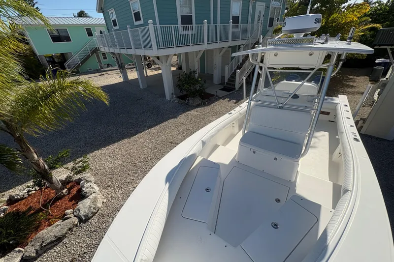 Slide: The Image of 2006 Regulator 24 Classic boat parked near coastal homes, showcasing sleek design and spacious deck. - 18