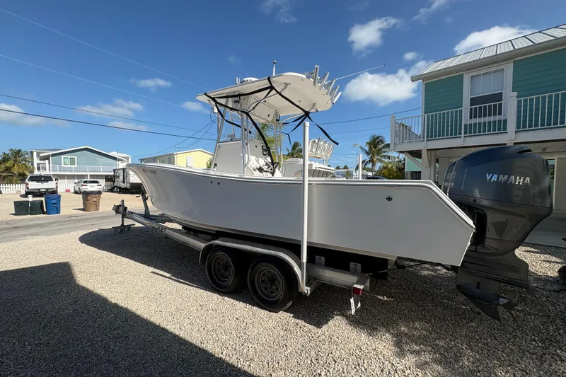 Slide: The Image of 2006 Regulator 24 Classic boat on trailer with Yamaha engine, parked in residential area. - 3