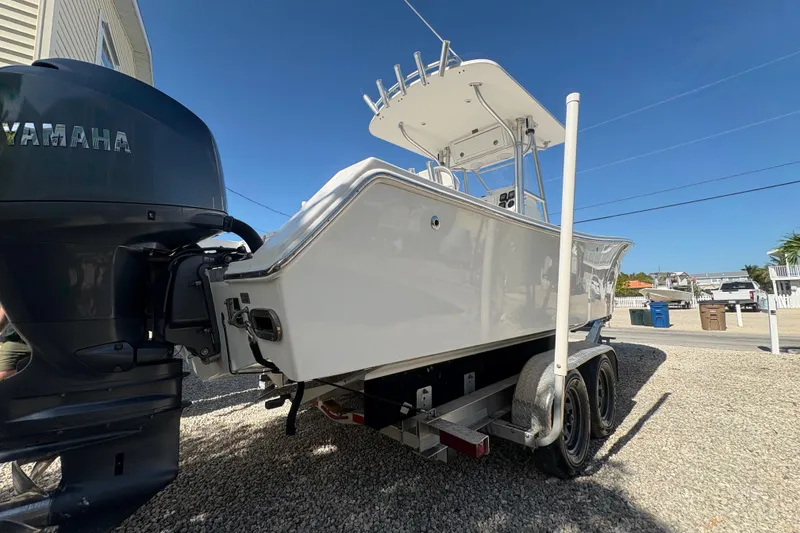 Slide: The Image of 2006 Regulator 24 Classic boat with Yamaha engine on trailer, parked outdoors. - 6