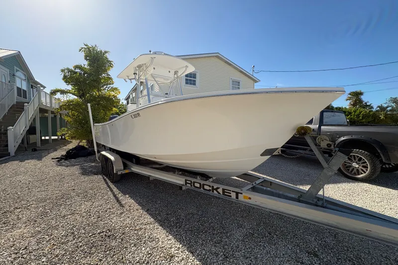 Slide: The Image of 2006 Regulator 24 Classic boat on trailer, parked in a gravel driveway. - 7