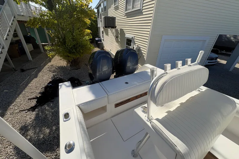 Slide: The Image of 2006 Regulator 24 Classic boat with dual engines, parked near a house. - 8