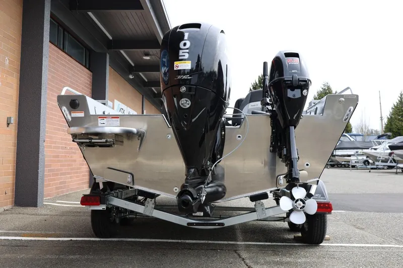Slide: The Image of 2026 Thunder Jet 209 Rush OT boat with dual outboard motors, parked outdoors. - 12