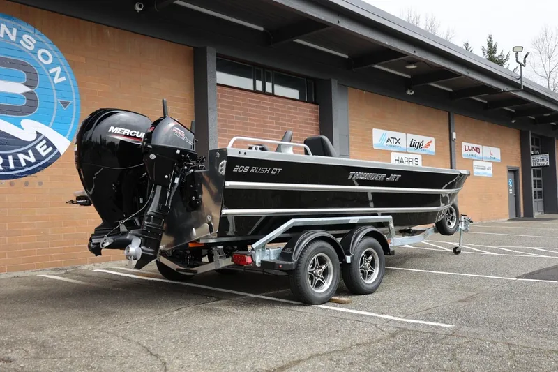 Slide: The Image of 2026 Thunder Jet 209 Rush OT boat on trailer outside marine dealership. - 15