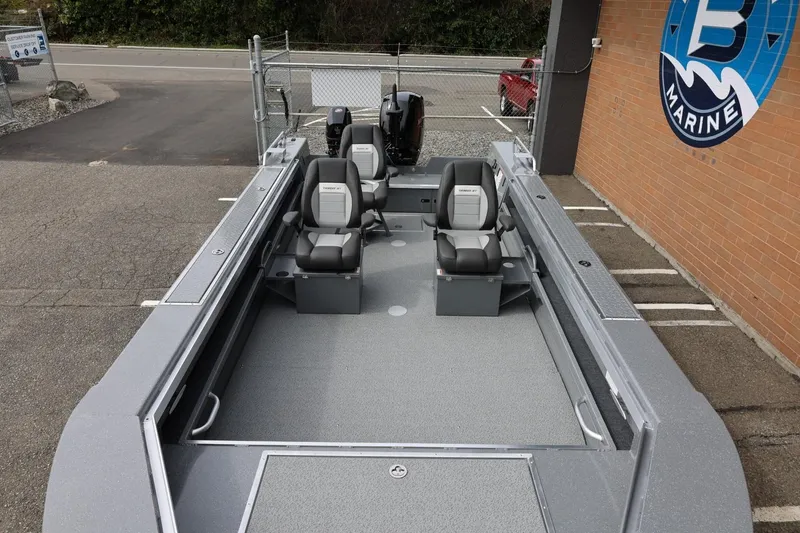 Slide: The Image of 2026 Thunder Jet 209 Rush OT boat with four seats, parked at a marine dealership. - 16