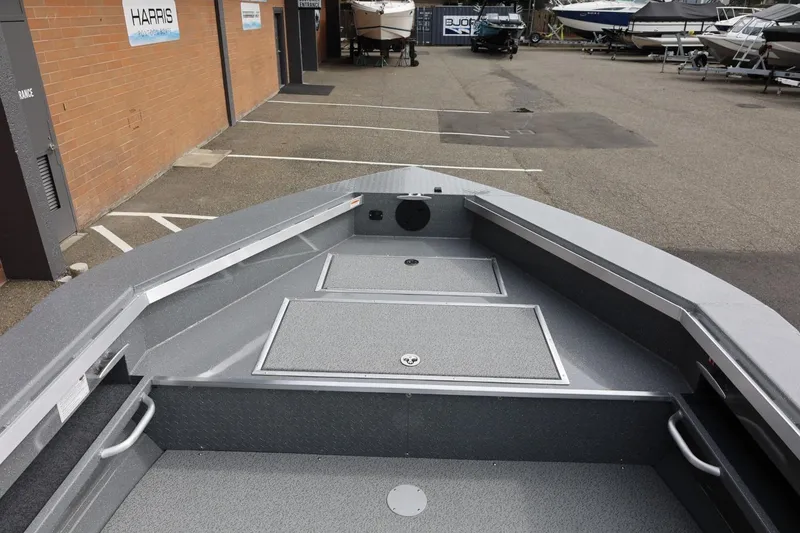 Slide: The Image of 2026 Thunder Jet 209 Rush OT boat interior at a dealership, showcasing storage compartments. - 20