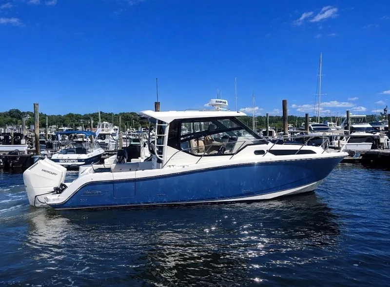 The Image of 2024 Boston Whaler 325 Conquest boat docked in sunny marina. - 0
