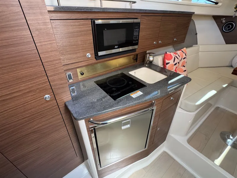 Slide: The Image of Interior of 2024 Boston Whaler 325 Conquest with kitchen and seating area. - 20