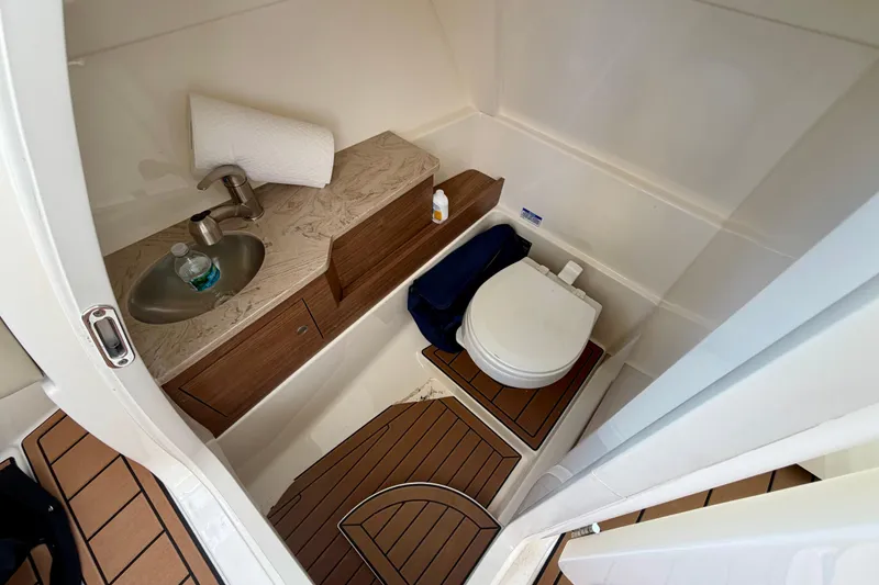Slide: The Image of 2022 Boston Whaler 280 Vantage boat bathroom with sink, toilet, and wooden flooring. - 16