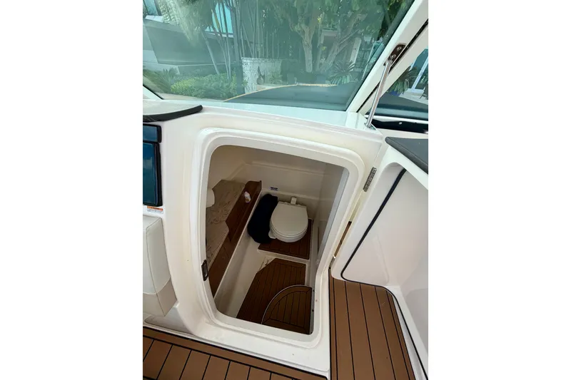 Slide: The Image of 2022 Boston Whaler 280 Vantage boat interior with compact marine toilet. - 17