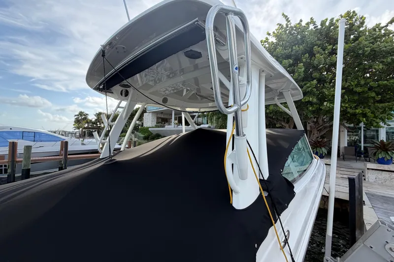 Slide: The Image of 2022 Boston Whaler 280 Vantage boat docked, covered with black tarp, surrounded by trees. - 19