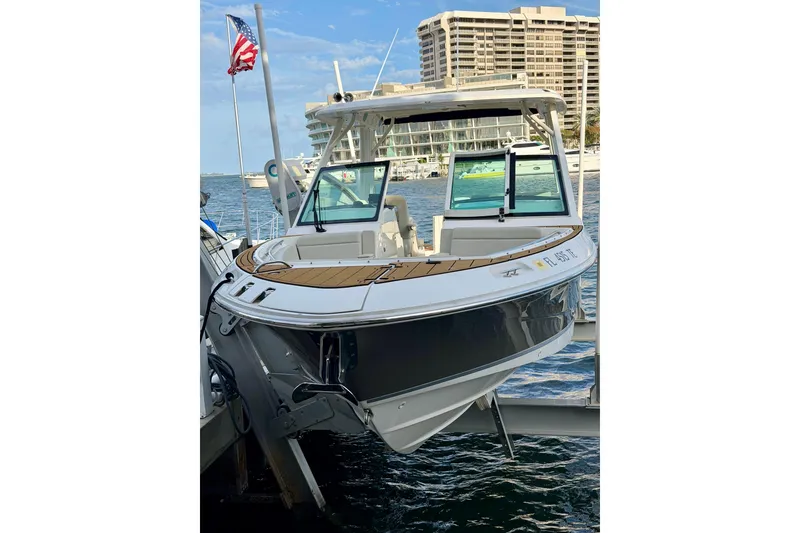 Slide: The Image of 2022 Boston Whaler 280 Vantage boat docked near waterfront buildings. - 2