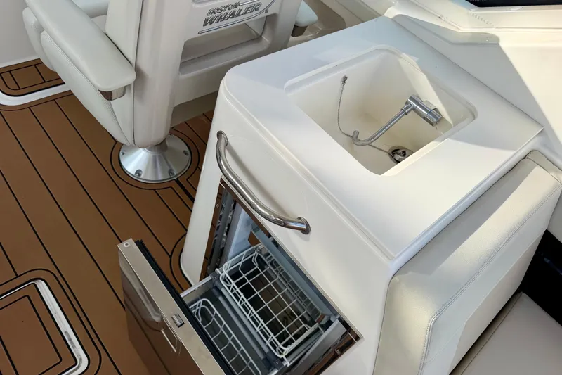 Slide: The Image of Boston Whaler 280 Vantage 2022 boat interior with sink and open storage compartment. - 21