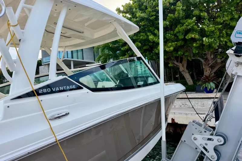 Slide: The Image of 2022 Boston Whaler 280 Vantage boat docked near lush greenery. - 4