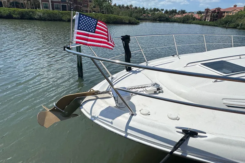 Slide: The Image of 2002 Sea Ray 380 Sundancer yacht with American flag on calm water. - 10