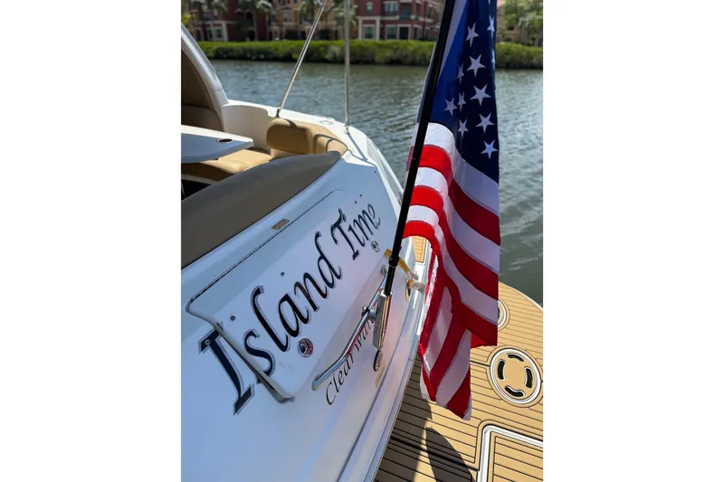 Slide: The Image of 2002 Sea Ray 380 Sundancer boat with American flag and "Island Time" nameplate. - 13