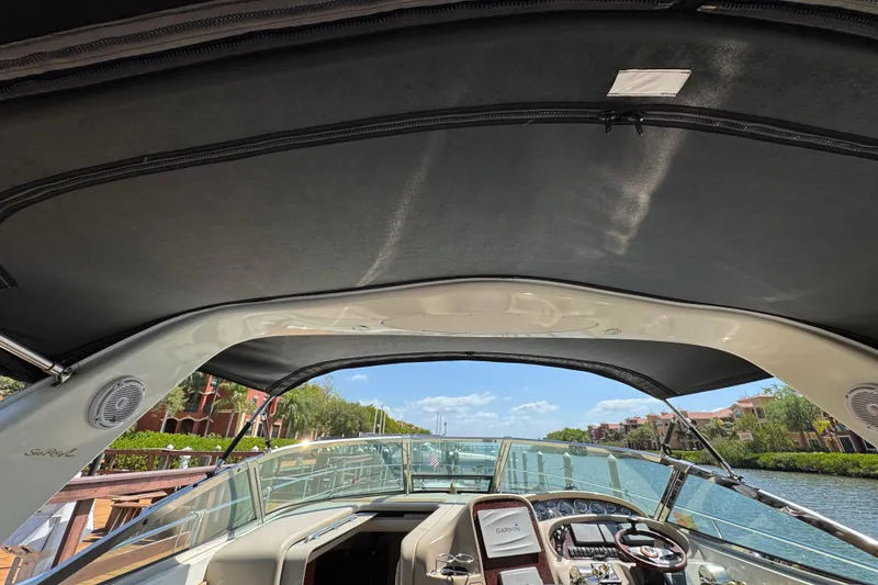 Slide: The Image of Cockpit view of 2002 Sea Ray 380 Sundancer yacht with canopy and waterfront scenery. - 19